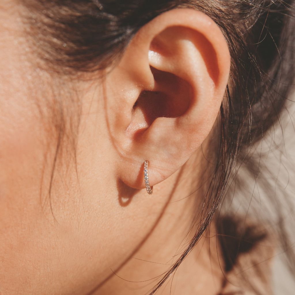 small huggie hoop earrings with diamond look crystals embedded throughout