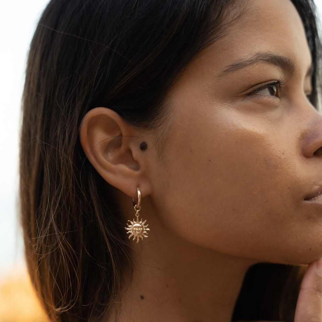 women's gold sun charm huggie earrings